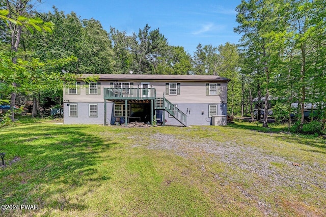 rear view of house with a wooden deck and a yard