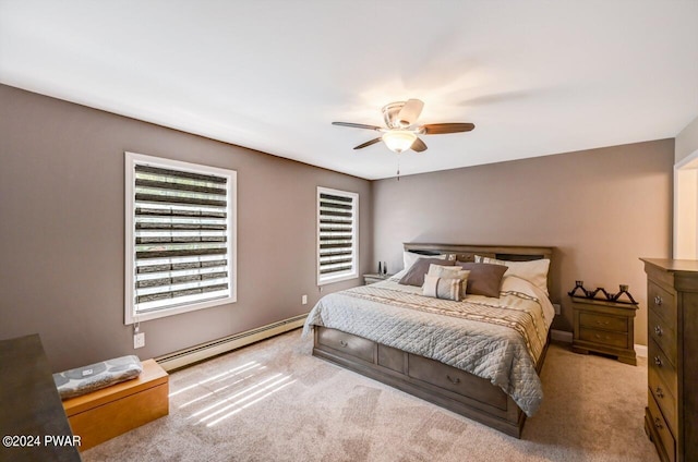 carpeted bedroom with ceiling fan and baseboard heating