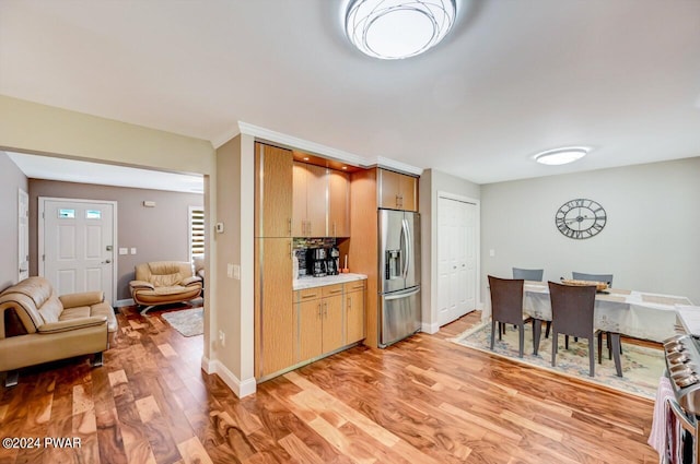 kitchen featuring stainless steel fridge with ice dispenser and light hardwood / wood-style flooring