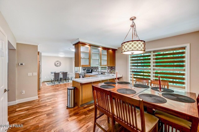 dining space with sink and light wood-type flooring