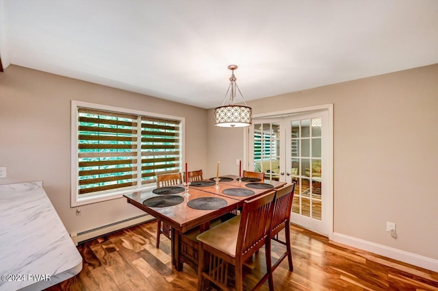 dining room with french doors, a baseboard radiator, and hardwood / wood-style floors