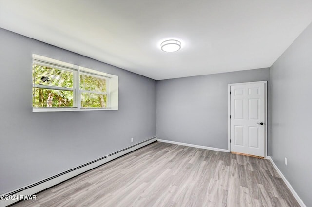 spare room featuring light hardwood / wood-style flooring and a baseboard heating unit