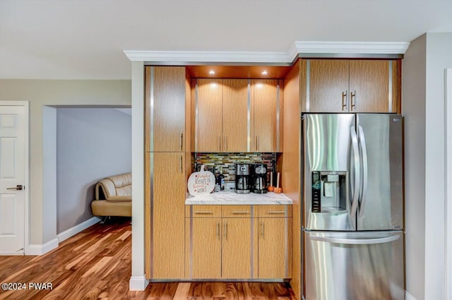 kitchen featuring backsplash, stainless steel refrigerator with ice dispenser, and hardwood / wood-style flooring