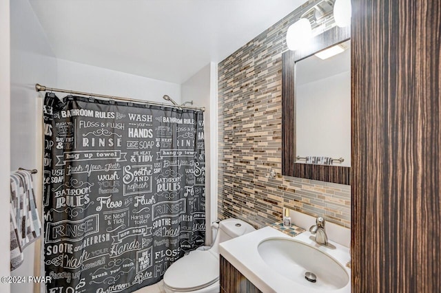 bathroom featuring walk in shower, tasteful backsplash, vanity, and toilet