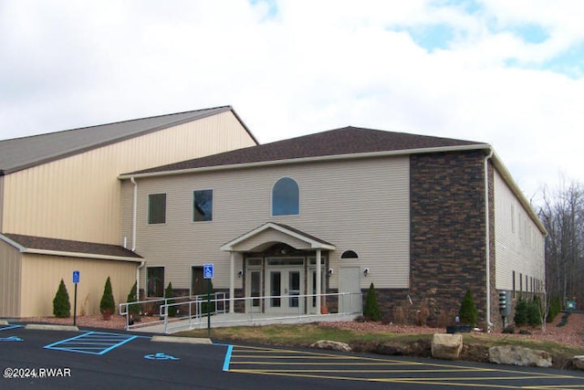 exterior space with uncovered parking, french doors, and brick siding