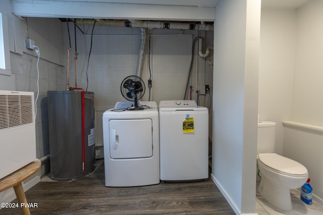 washroom with laundry area, baseboards, washer and clothes dryer, dark wood-type flooring, and electric water heater