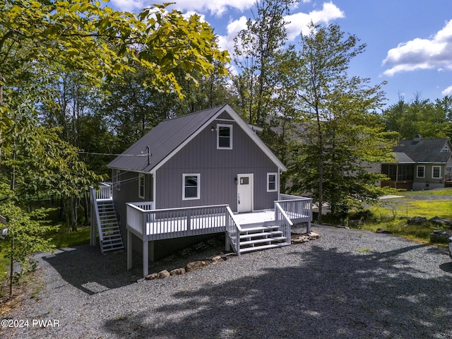 view of front facade with a sunroom, a deck, and stairs