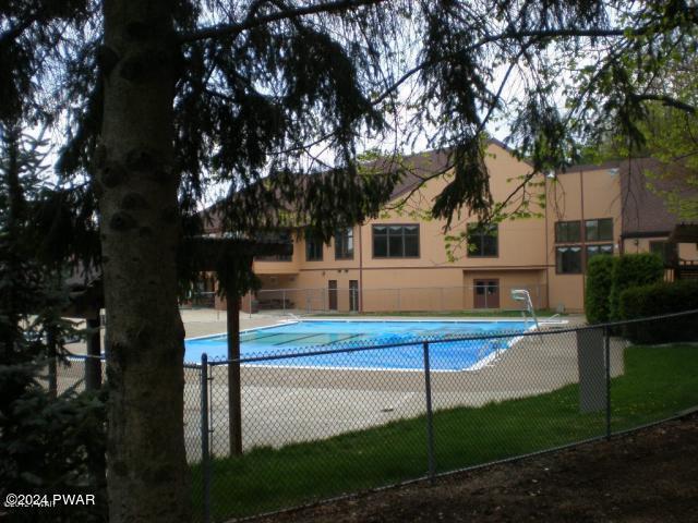 view of swimming pool featuring fence