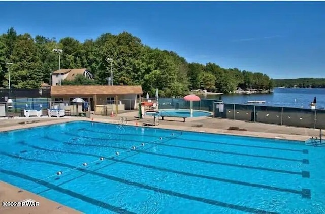 view of pool featuring a water view and fence