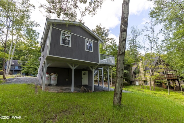 exterior space featuring a wooden deck and a lawn