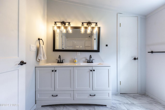 bathroom featuring marble finish floor, a sink, baseboards, and double vanity