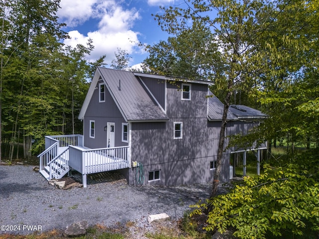 back of house with metal roof and a wooden deck