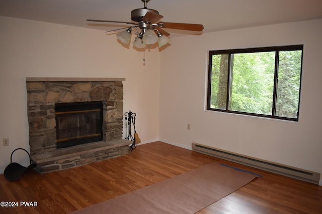 unfurnished living room featuring baseboard heating, ceiling fan, a fireplace, and wood-type flooring