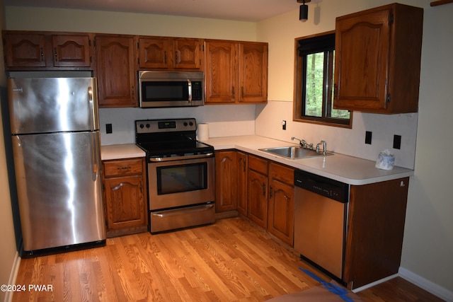 kitchen with sink, light hardwood / wood-style floors, and appliances with stainless steel finishes