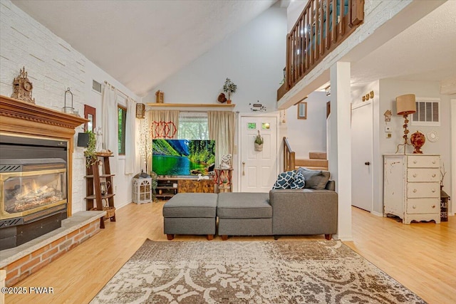 102 Keystone Ct, Dingmans Ferry, PA 18328 - living room with stairway, wood finished floors, high vaulted ceiling, and a glass covered fireplace