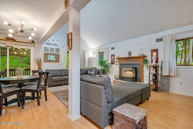 102 Keystone Ct, Dingmans Ferry, PA 18328 - living area with lofted ceiling, a chandelier, light wood finished floors, and a fireplace