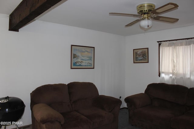 living area featuring beam ceiling and a ceiling fan
