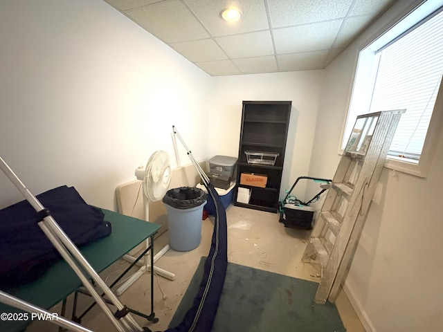 misc room with a paneled ceiling and baseboards