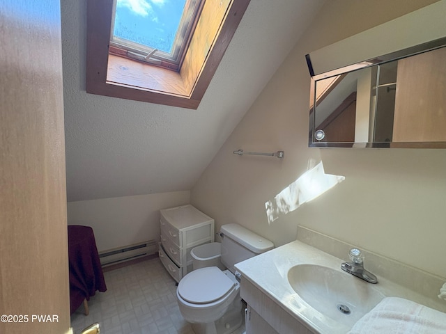 bathroom with baseboard heating, lofted ceiling, vanity, toilet, and a skylight