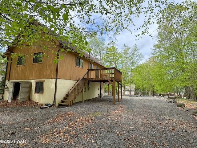 view of side of property with stairway, a deck, and driveway