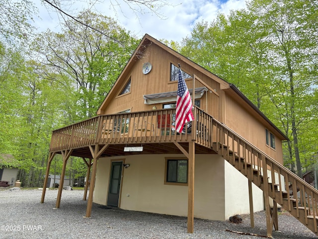 back of house featuring a wooden deck and stairs