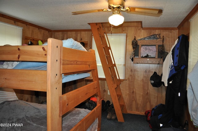 bedroom with wood walls, carpet, and crown molding