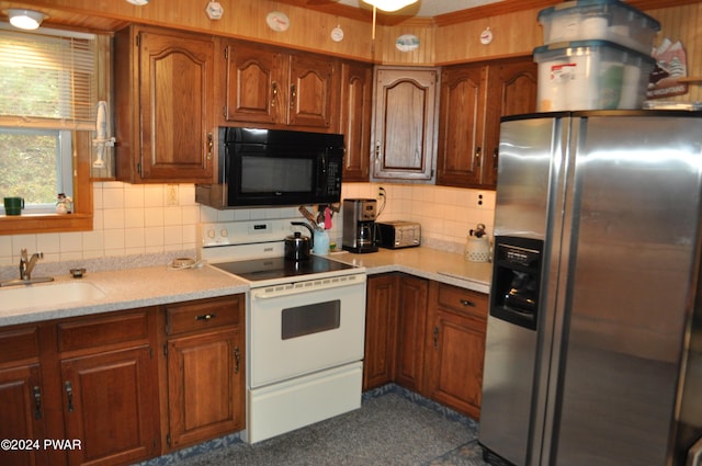 kitchen with black microwave, a sink, light countertops, stainless steel fridge with ice dispenser, and white electric range oven