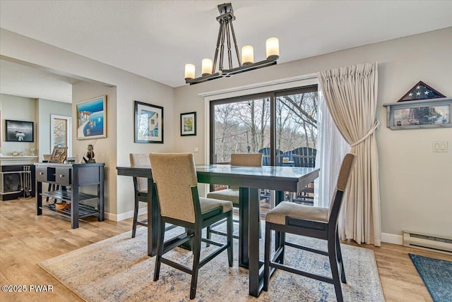 113 Marina Village Ln, Greentown, PA 18426 - dining space featuring baseboards, light wood finished floors, a baseboard radiator, and an inviting chandelier