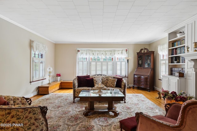 living room with crown molding, a wealth of natural light, and light wood-type flooring
