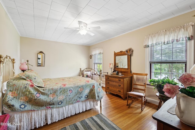 bedroom featuring crown molding, ceiling fan, and wood finished floors