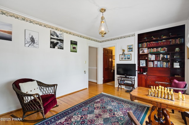 sitting room with crown molding, baseboards, and wood finished floors