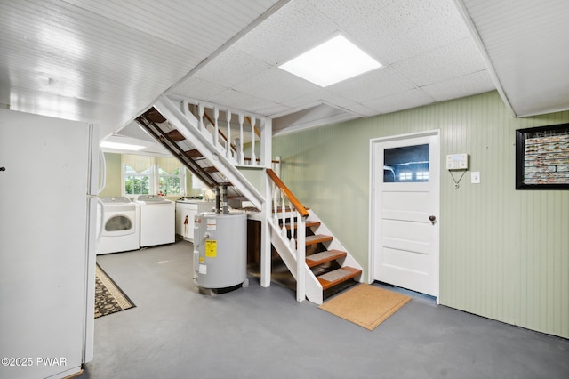 basement with freestanding refrigerator, stairs, independent washer and dryer, and water heater