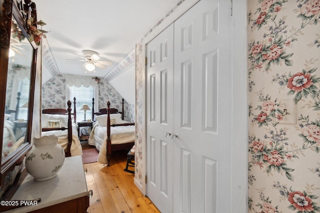 bedroom featuring a ceiling fan, light wood-style flooring, and wallpapered walls
