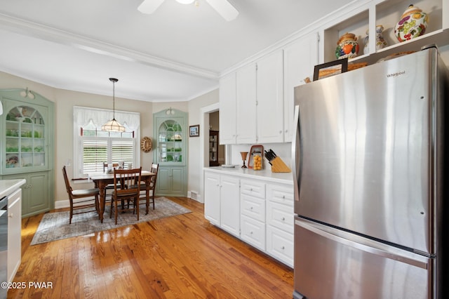 kitchen with freestanding refrigerator, light wood-style floors, light countertops, white cabinetry, and a ceiling fan