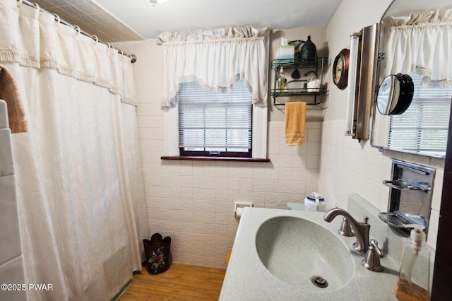 bathroom featuring tile walls, curtained shower, wood finished floors, and a wealth of natural light