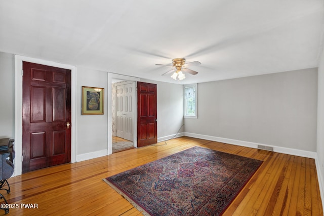interior space featuring baseboards, ceiling fan, and wood-type flooring