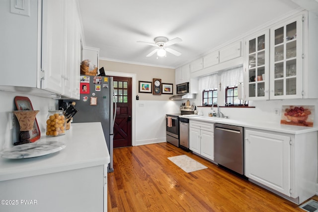 kitchen featuring plenty of natural light, crown molding, appliances with stainless steel finishes, and white cabinets