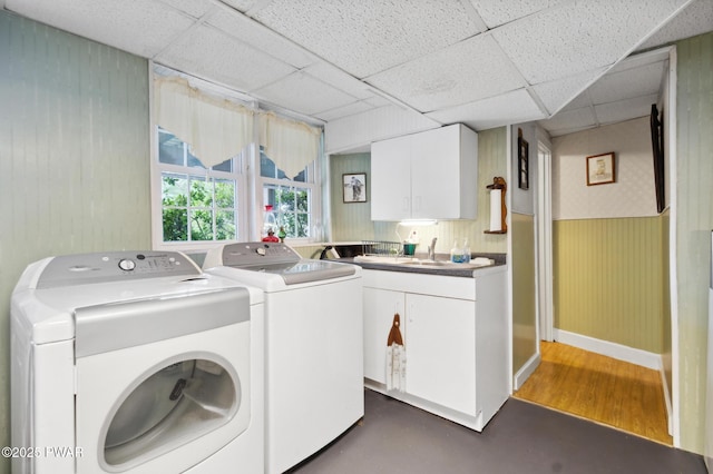 laundry room with washer and dryer, cabinet space, a sink, a wainscoted wall, and baseboards