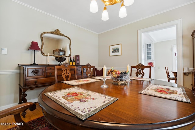 dining space with a chandelier, ornamental molding, and wood finished floors