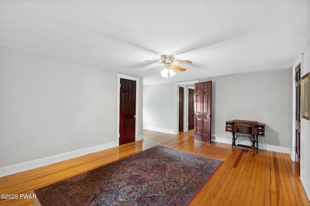 unfurnished room featuring baseboards, a ceiling fan, and light wood-style flooring