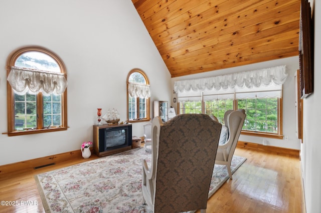living room featuring high vaulted ceiling, baseboards, wood finished floors, and visible vents