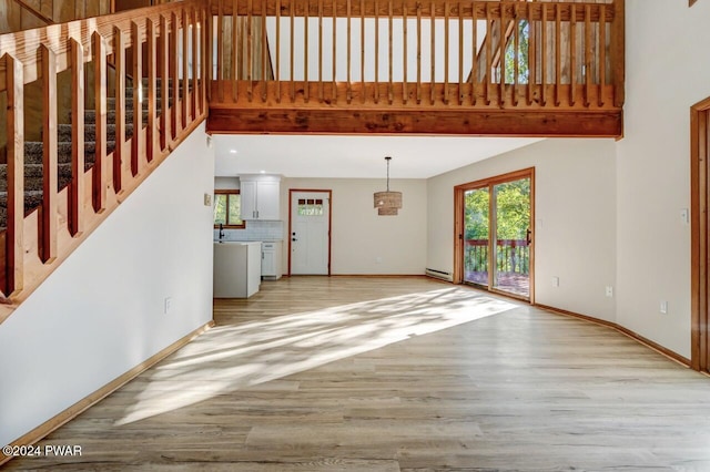 unfurnished living room featuring sink and light hardwood / wood-style floors