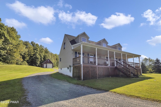 view of front of property with covered porch, an outbuilding, a garage, and a front yard