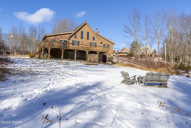 snow covered property with a deck