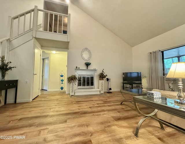 235 Falling Waters Blvd, Lackawaxen, PA 18435 - living area with high vaulted ceiling, wood finished floors, and a glass covered fireplace