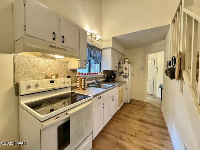 235 Falling Waters Blvd, Lackawaxen, PA 18435 - kitchen with white appliances, under cabinet range hood, decorative backsplash, light wood-style floors, and white cabinets