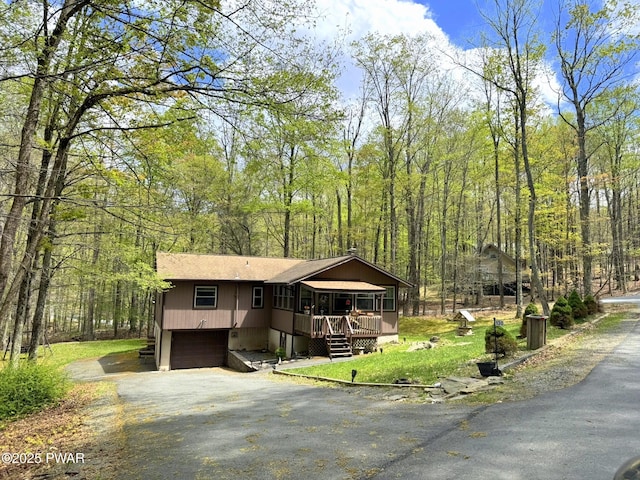 130 Grasshopper Ln, Greentown, PA 18426 - view of front of house featuring asphalt driveway, an attached garage, a wooded view, and roof with shingles