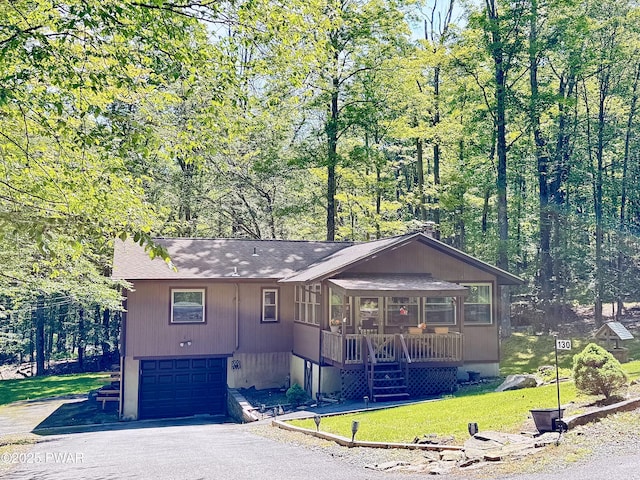 130 Grasshopper Ln, Greentown, PA 18426 - view of front of property with a garage, asphalt driveway, a front yard, a shingled roof, and a porch