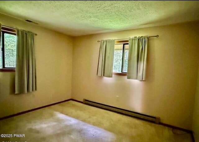 empty room featuring a textured ceiling and a baseboard heating unit