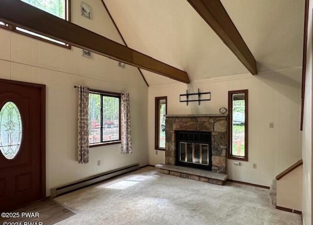 unfurnished living room with a healthy amount of sunlight, light carpet, a baseboard heating unit, a stone fireplace, and beam ceiling